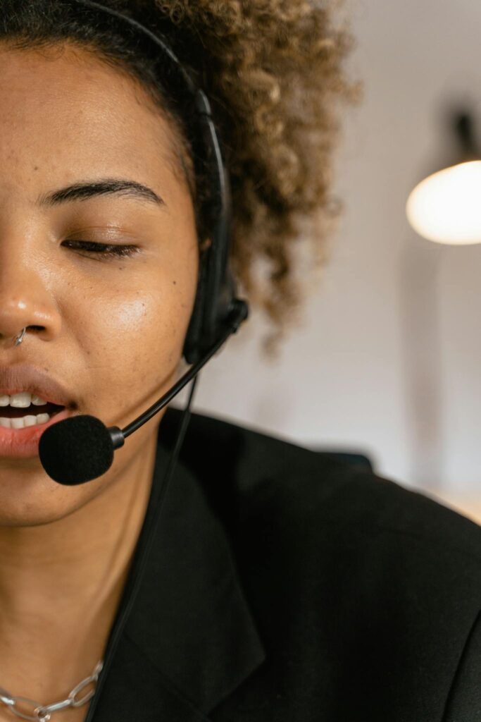 Close-up of a woman wearing a headset, engaged in customer support, working in an office.